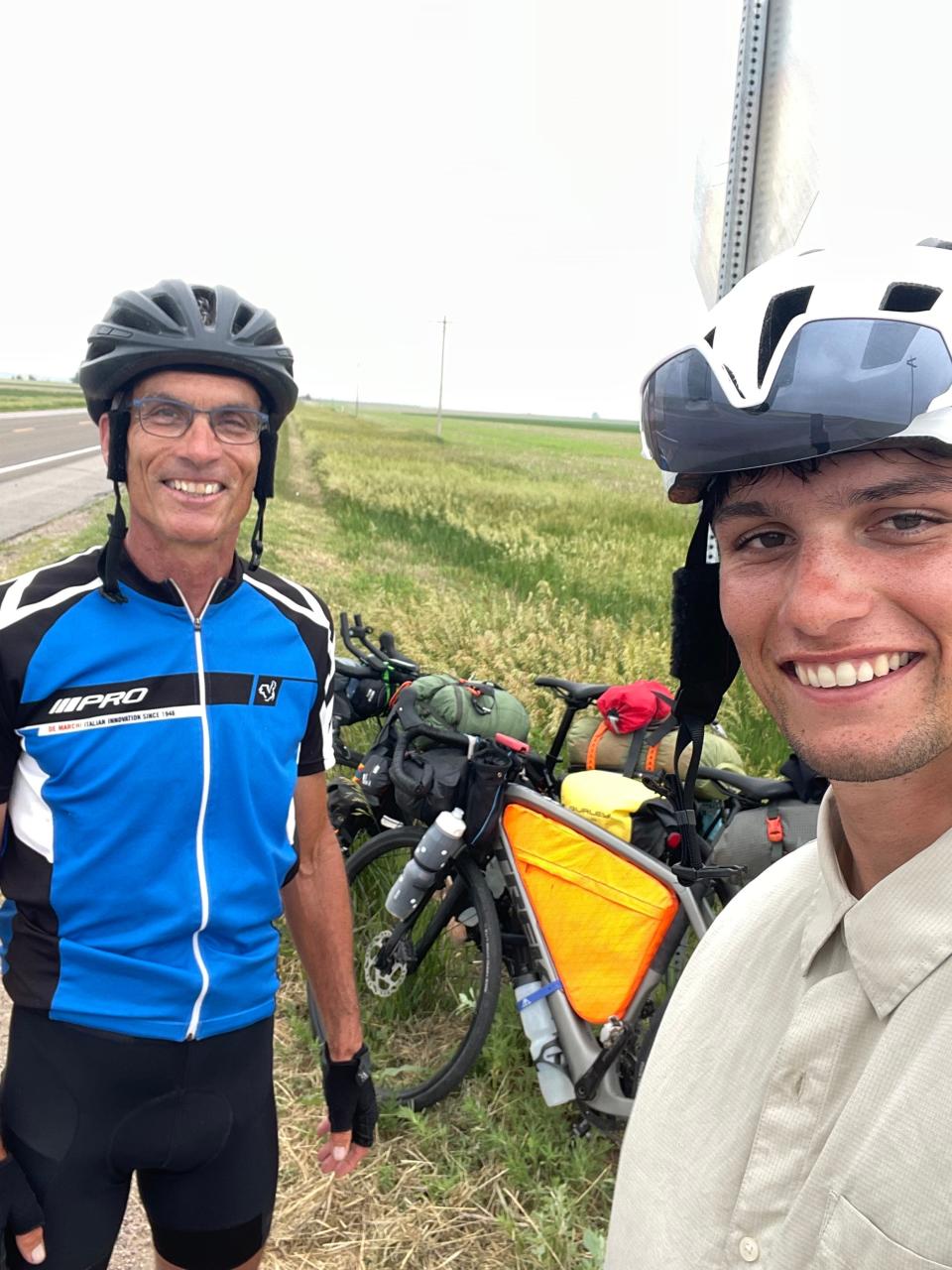 Sam and Chick Westby stop for a selfie on the side of a highway. The father-son duo from Wisconsin completed a 42-day, 3,600-mile cross-country bike trip on July 12, 2023.