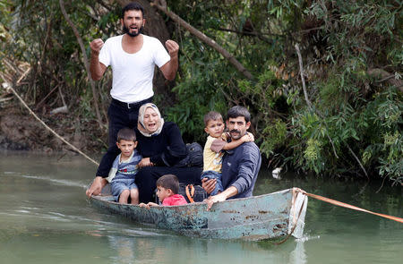 FILE PHOTO: A Syrian family crosses to Turkey by boat over the Orontes river on the Turkish-Syrian border near the village of Hacipasa, Hatay province, Syria October 10, 2012. REUTERS/Osman Orsal/File Photo