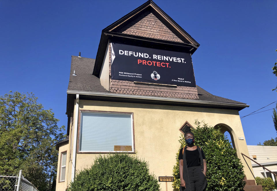 Shanice Clarke is shown standing in front of the childhood home of black community leader Avel Gordly, the first Black woman elected to the Oregon State Senate in Portland, Ore., on Tuesday, Sept. 1, 2020. Once hailed as one of the most livable cities in the U.S., Portland, Oregon, is grappling with an uncertain future as it reaches a stunning benchmark: 100 consecutive nights of racial injustice protests. (AP Photo/Gillian Flaccus)