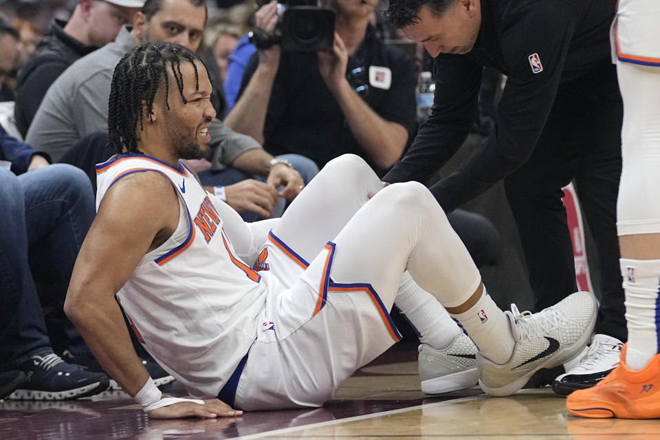 New York Knicks guard Jalen Brunson (11) is tended to after an injury in the first half of an NBA basketball game against the Cleveland Cavaliers, Sunday, March 3, 2024, in Cleveland. (AP Photo/Sue Ogrocki)