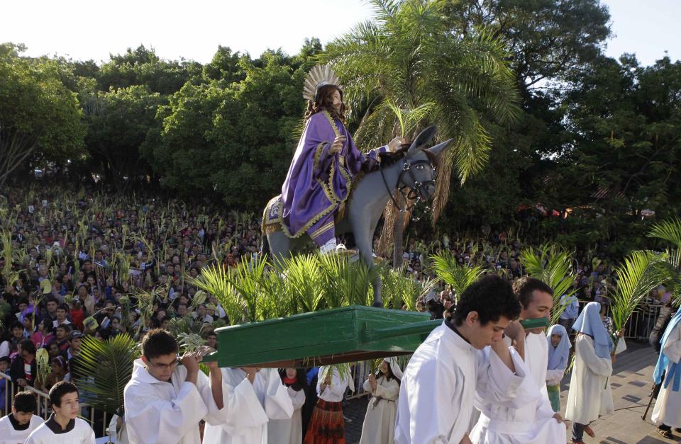 Catholics carry a statue of Jesus Christ on a donkey during a Palm Sunday procession outside the Metropolitan Cathedral in Caacupe April 13, 2014. Palm Sunday commemorates Jesus Christ's triumphant entry into Jerusalem on the back of a donkey and marks the start of Holy Week. REUTERS/Jorge Adorno (PARAGUAY - Tags: RELIGION)