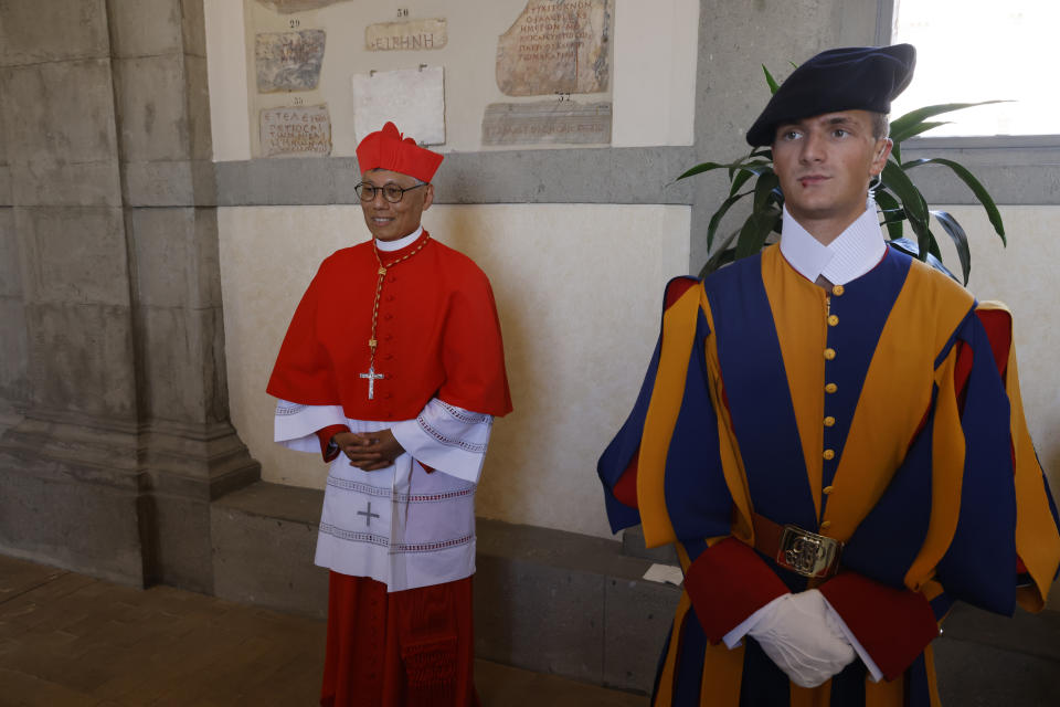 FILE - Cardinal Stephen Chow, Bishop of Hong Kong poses for a photo next to a pontifical Swiss guard, right, at the end of the consistory where Pope Francis elevated 21 new cardinals in St. Peter's Square at The Vatican, Saturday, Sept. 30, 2023. Pope Francis is convening a global gathering of bishops and laypeople to discuss the future of the Catholic Church, including some hot-button issues that have previously been considered off the table for discussion. Key agenda items include women's role in the church, welcoming LGBTQ+ Catholics and how bishops exercise authority. For the first time, women and laypeople can vote on specific proposals alongside bishops.(AP Photo/Riccardo De Luca, File)