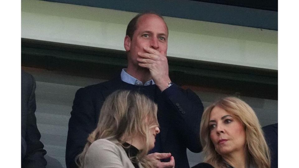 Prince William with his hand over his mouth