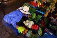 A man buys vegetables at a stall in an outdoor market in downtown of Ciudad Juarez