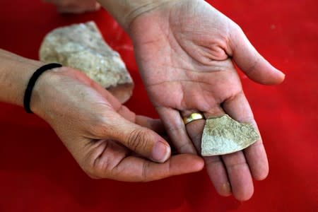 An archaeologist from the Israel Antiquities Authority shows off one of the findings discovered at the site where the remains of a mosque was uncovered and which the authority say is one of the world's oldest mosques, in the outskirts of Rahat