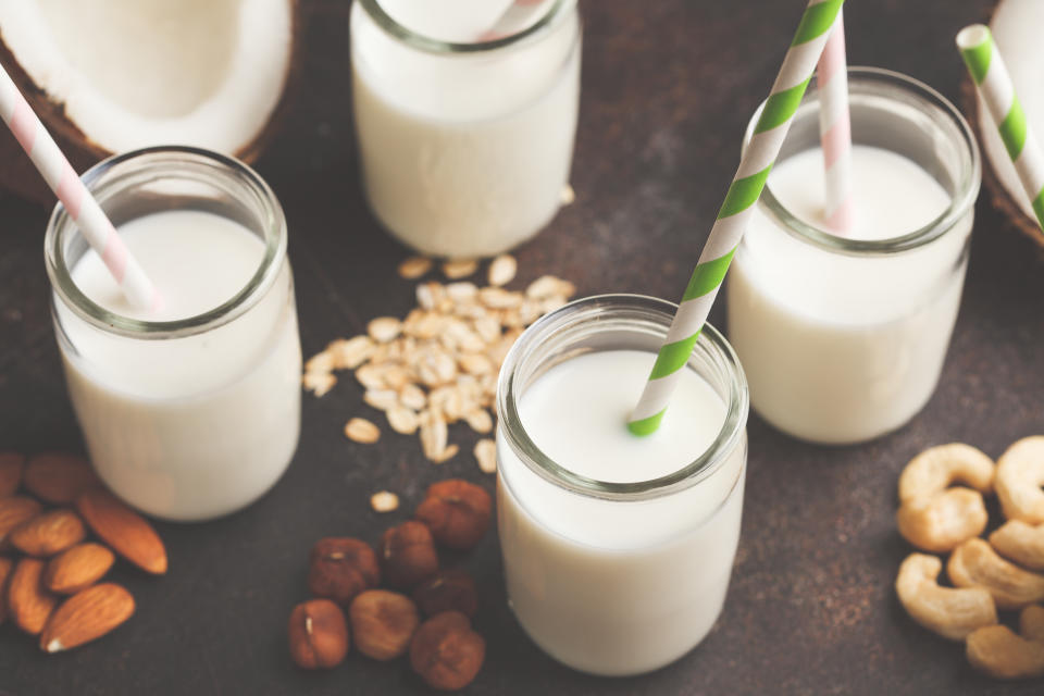 Vegan alternative nut milk in glass bottles on dark background. Healthy food background. Healthy vegan food concept.