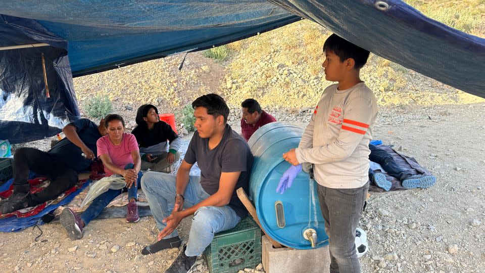 A family fleeing political threats waits to be apprehended after crossing the US-Mexico border into Arizona. - Norma Galeana/CNN