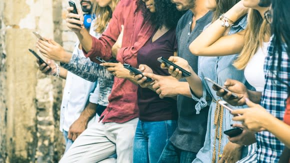 A group of people using smartphones outside.