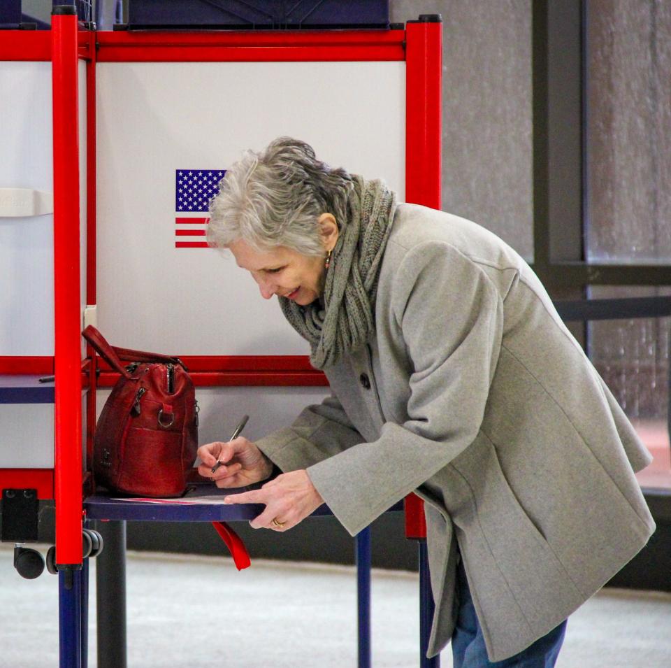 A voter casts her ballots at Precinct 7B, at Fall River Government Center, for the presidential primary on March 5, 2024.
