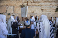 Ultra-Orthodox Jewish men wear protective mace masks during morning prayer at the Western Wall, the holiest site where Jews can pray, in Jerusalem's Old City, Thursday, July 16, 2020. The Western Wall plaza is divided to sections which allowed maximum twenty people following the government's measures to help stop the spread of the coronavirus. (AP Photo/Oded Balilty)