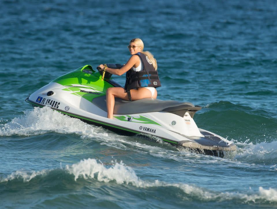 Model Sofia Richie, wearing white thong bikini and Givenchy flip flops, is shocked at how cold the water is after jumping off a jet ski in Miami Beach, Florida. Source: Splash