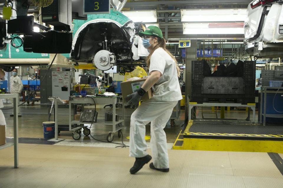 An autoworker carries a box on the production line for the Honda CRV at a Honda plant in Alliston, Ont., in March 2022. THE CANADIAN PRESS/Chris Young