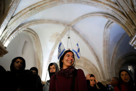 A visitor wears a headband with Israeli flags attached to it as she stands in the Cenacle, a hall revered by Christians as the site of Jesus' Last Supper, in Mount Zion near Jerusalem's Old City March 14, 2019. REUTERS/Amir Cohen