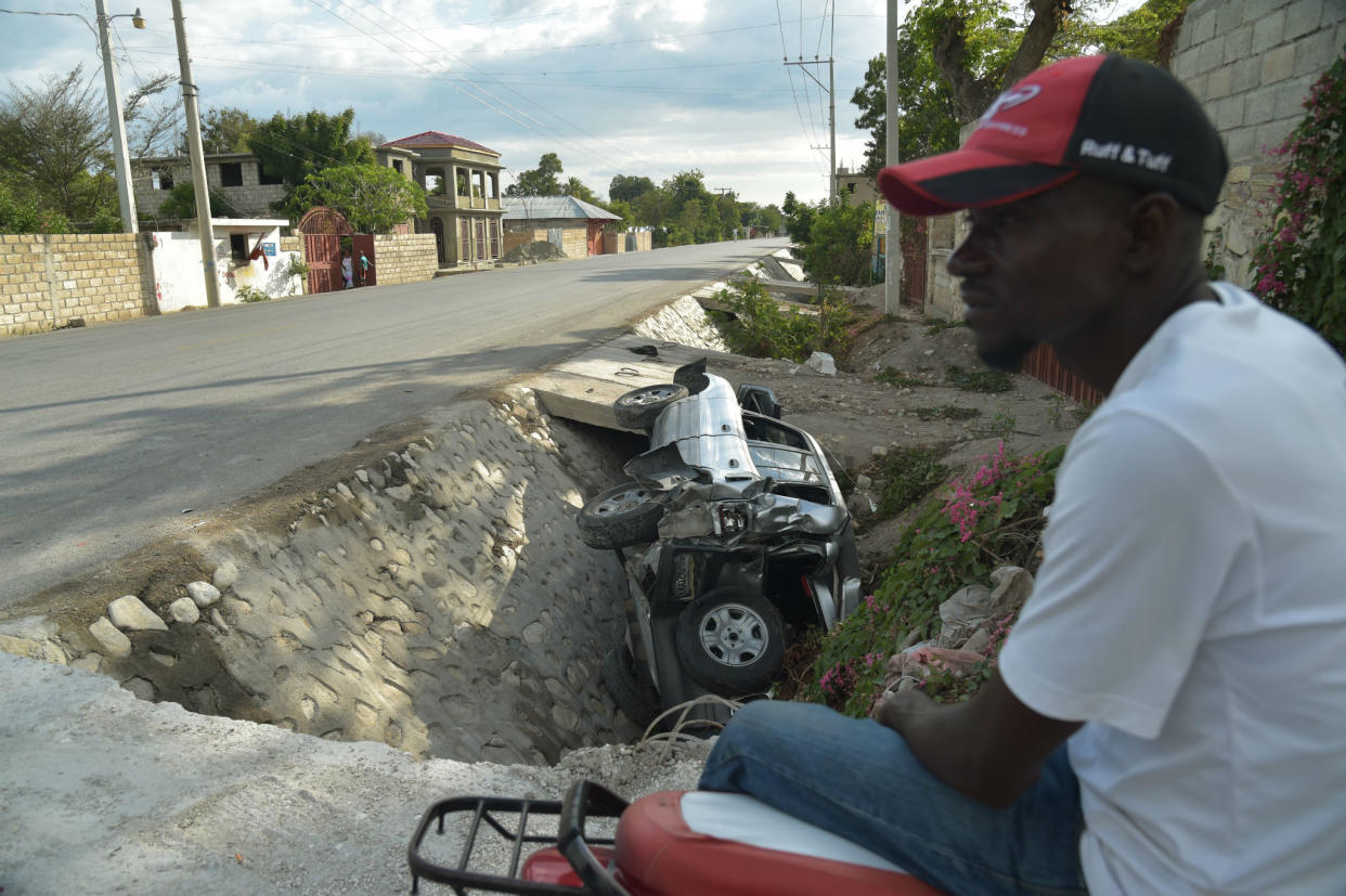 A car damaged by a bus lies on the side of a road yesterday in Gonaives, 150 km (90 miles) northwest of the capital Port-au-Prince: Getty