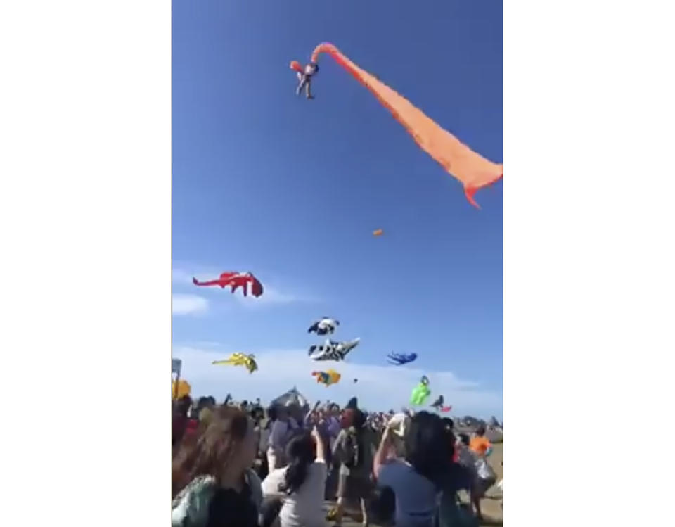 In this image made from video, a 3 year old girl is lifted into the air by a large kite during a kite festival in Hsinchu, northern Taiwan, Sunday, Aug. 30, 2020. The wind slowed down and the girl was safely recovered by adults on the ground. (Credit: Dainese Hsu)