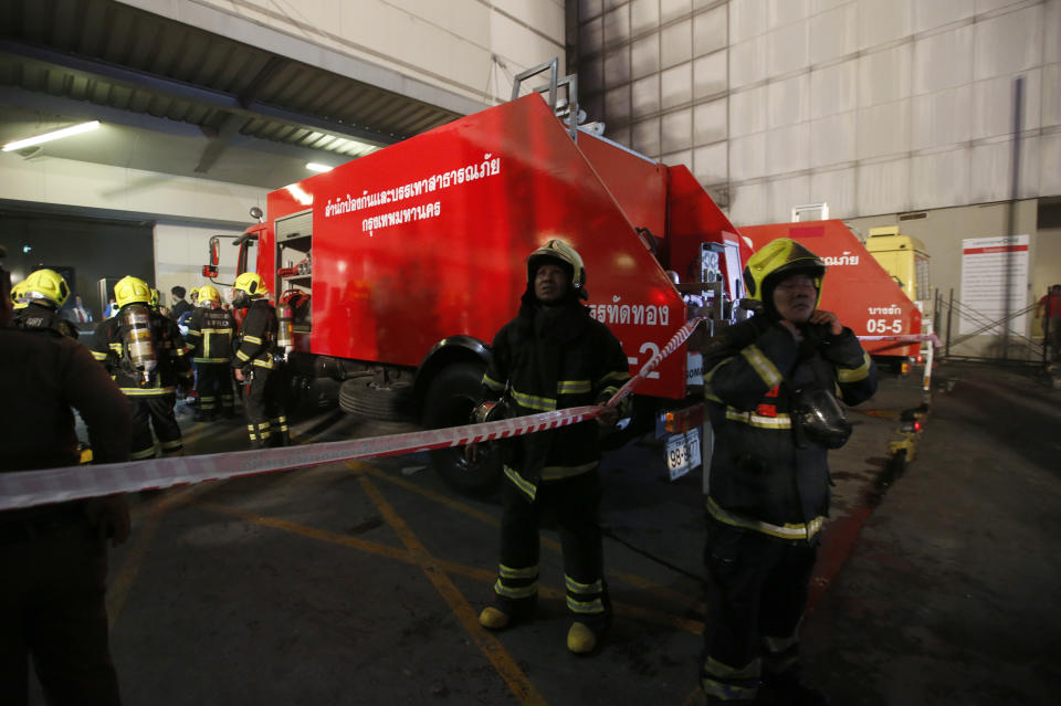 Firefighters work at the scene of a fire outside a mall complex, Wednesday, April 10, 2019, in downtown Bangkok, Thailand. The fire had broken out in the Central World mall complex in Thailand's capital, with reports from emergency services saying it has caused a number of fatalities. (AP Photo/Sakchai Lalit)