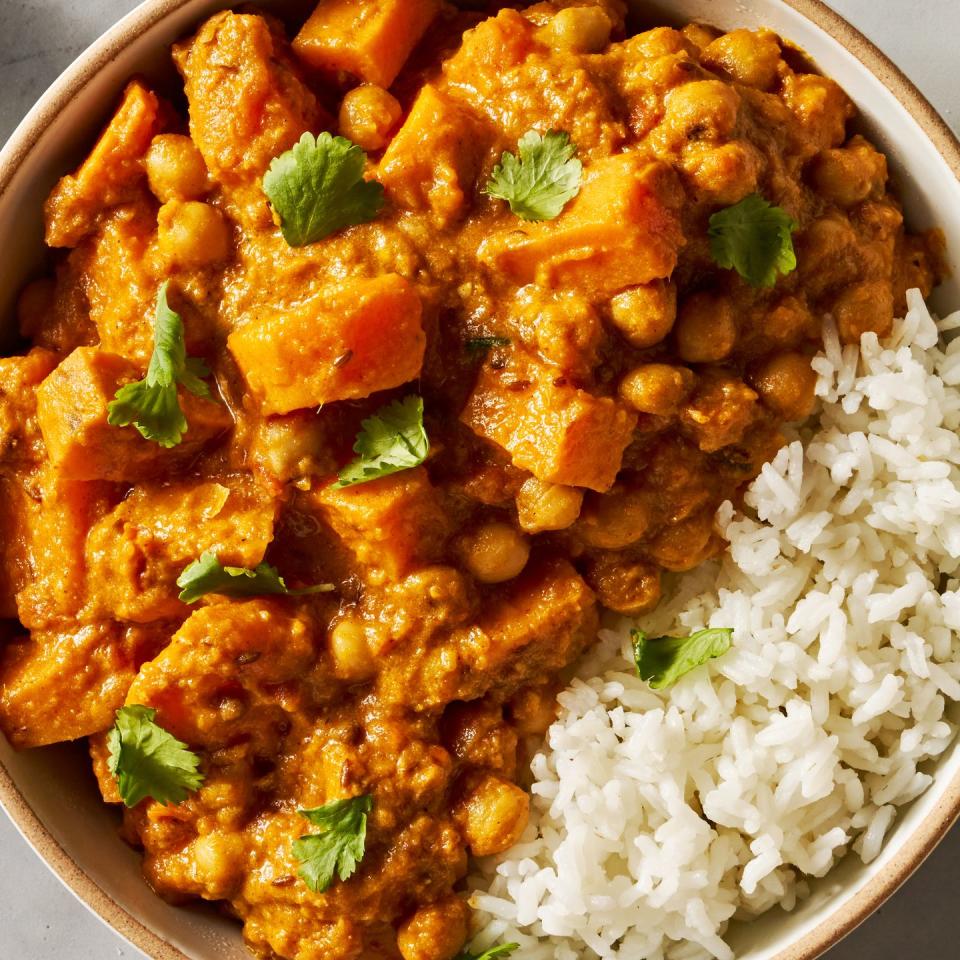 creamy orange coconut chickpea and sweet potato curry served with rice and topped with cilantro