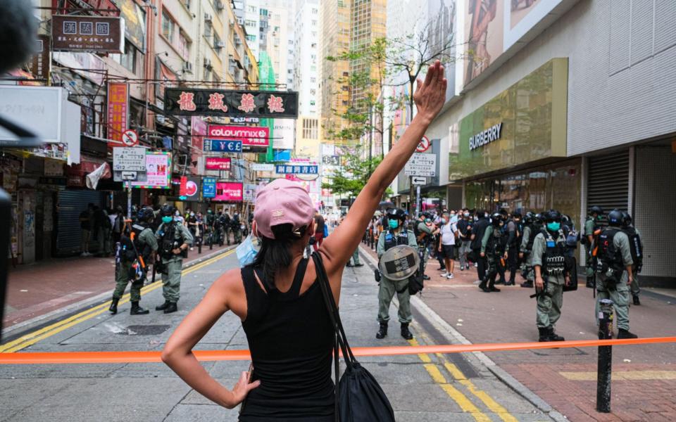 A girl holds up her hand to confront the police during a banned protest  - Zuma/Alamy/Zuma/Alamy