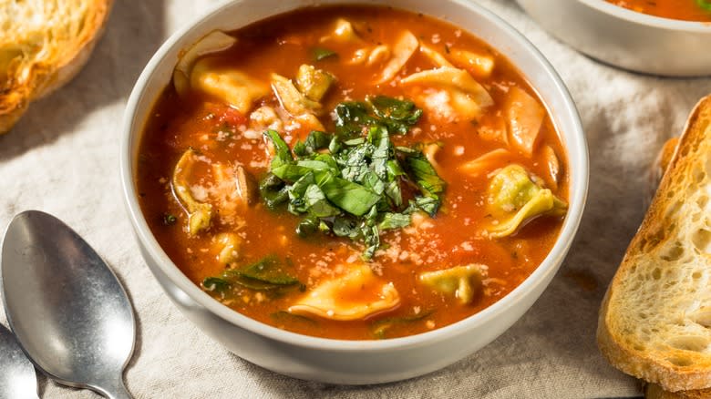 Bowl of soup with ravioli and basil