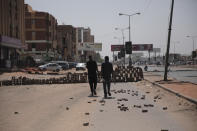 People walk on a street in Khartoum, Sudan, two days after a military coup, Wednesday, Oct. 27, 2021. The coup threatens to halt Sudan's fitful transition to democracy, which began after the 2019 ouster of long-time ruler Omar al-Bashir and his Islamist government in a popular uprising. It came after weeks of mounting tensions between military and civilian leaders over the course and pace of that process. (AP Photo/Marwan Ali)