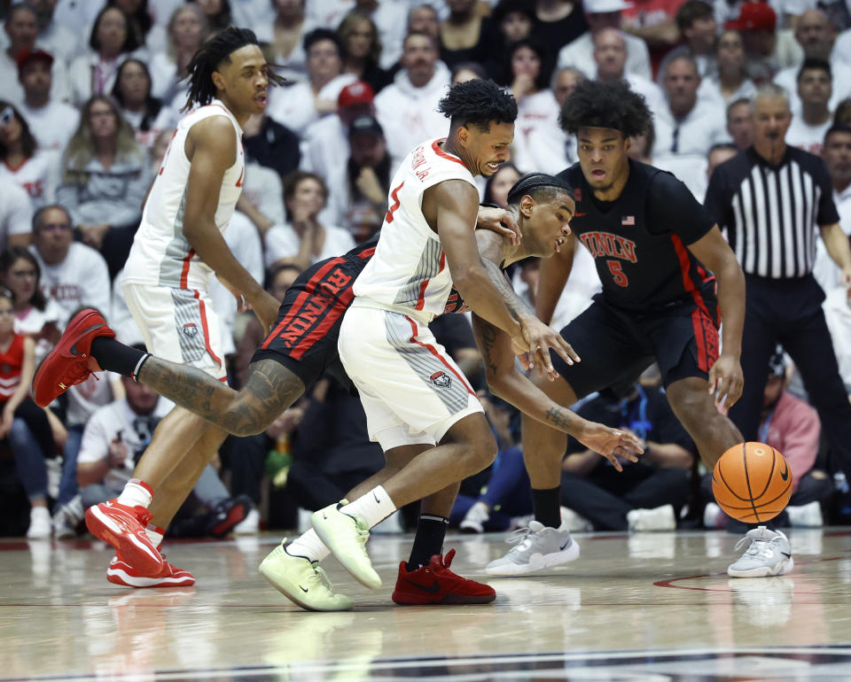 New Mexico guard Jamal Mashburn Jr. loses the ball as UNLV guard Luis Rodriguez defends during the first half of an NCAA college basketball game, Saturday, Feb. 10, 2024, in Albuquerque, N.M. Also pictured is New Mexico forward JT Toppin, left, and UNLV forward Rob Whaley Jr.. (AP Photo/Eric Draper)