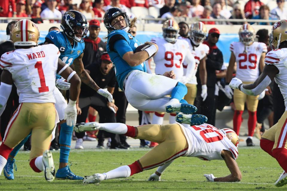 Jaguars quarterback Trevor Lawrence (16) twists and leaps over San Francisco 49ers cornerback Ambry Thomas (20) during the fourth quarter on Nov. 21.