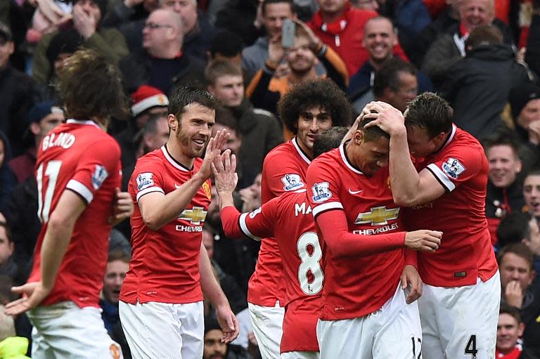 Manchester United's Chris Smalling (2nd R) celebrates with teammates after scoring during the Premier League match against Manchester City at Old Trafford on April 12, 2015