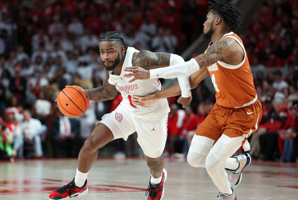 Houston's Jamal Shead drives past Texas' Tyrese Hunter in the Cougars' victory Saturday. Shead, a Manor High School graduate, had 16 points, 11 rebounds and six assists.