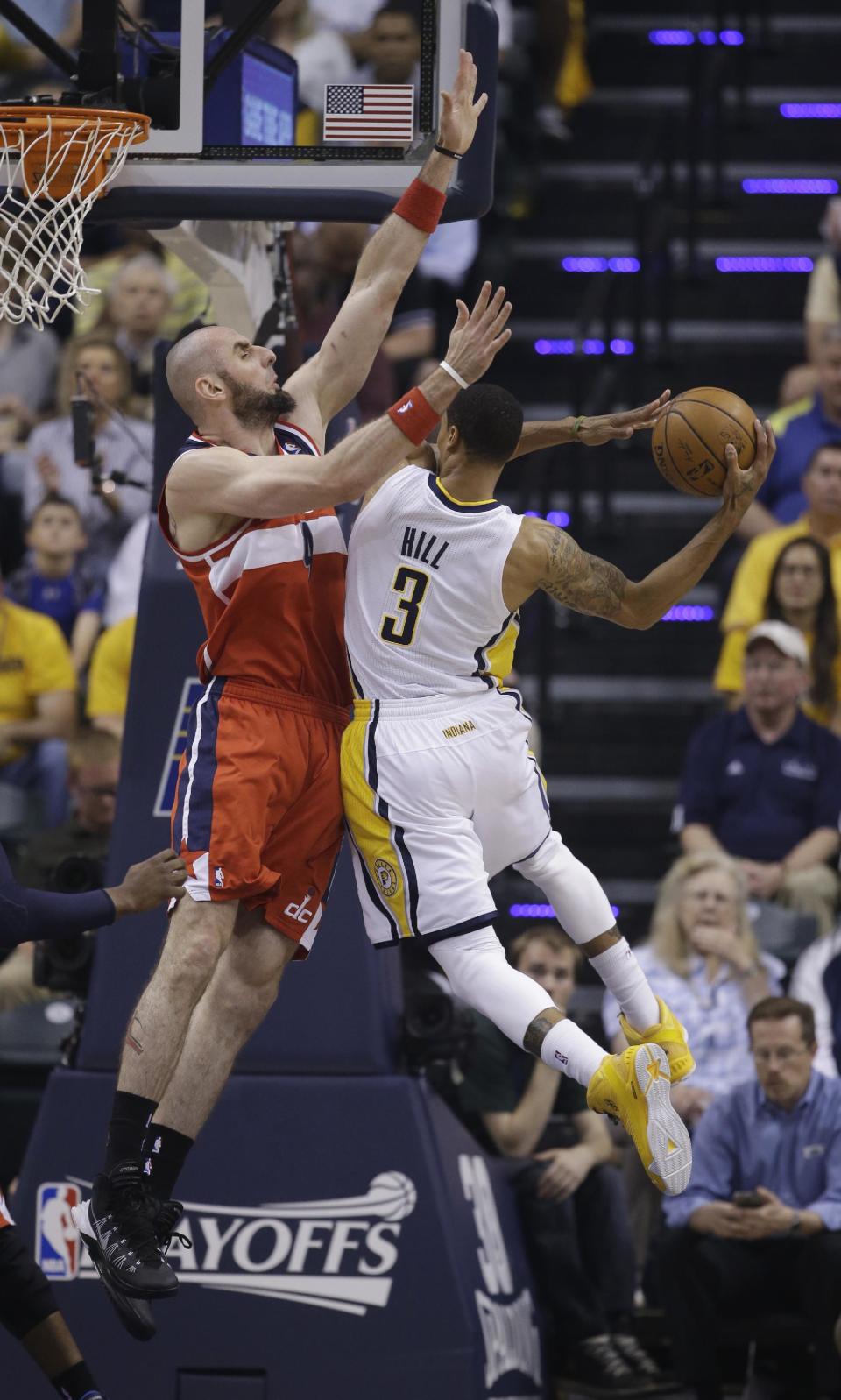 Washington Wizards center Marcin Gortat, left, goes up to block the shot of Indiana Pacers guard George Hill during the first half of game 5 of the Eastern Conference semifinal NBA basketball playoff series Tuesday, May 13, 2014, in Indianapolis. (AP Photo/Darron Cummings)