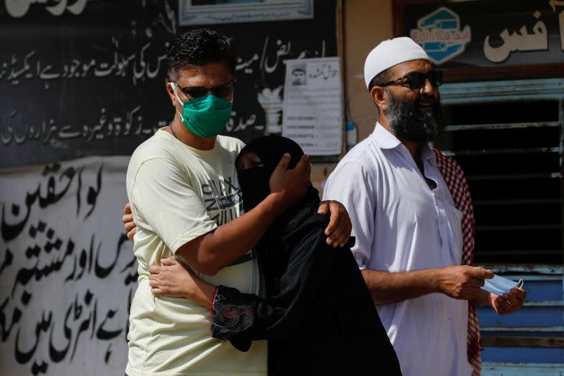 Family members mourn the death of a relative who was killed in a plane crash, outside a morgue in Karachi