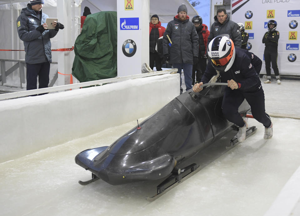 Kaillie Humphries, formerly of team Canada but now representing The United States, front, pushes her sled at the start of a training run for the women's World Cup bobsled event in Lake Placid, N.Y., on Friday, Dec. 6, 2019. Competition begins on Saturday. (AP Photo/Hans Pennink)