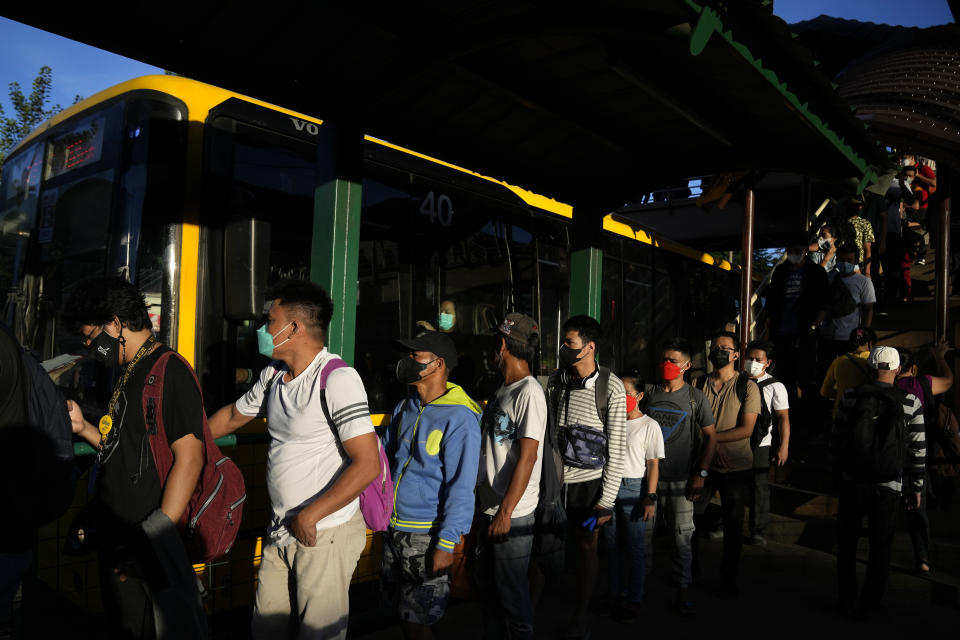 Passengers wearing face masks wait at a bus stop in Manila, Philippines on Sept. 8, 2022. Philippine President Ferdinand Marcos Jr. is extending a state of calamity declared by his predecessor more than two years ago to deal with continuing concerns over the coronavirus pandemic, an official said Monday, Sept. 12, 2022. (AP Photo/Aaron Favila)