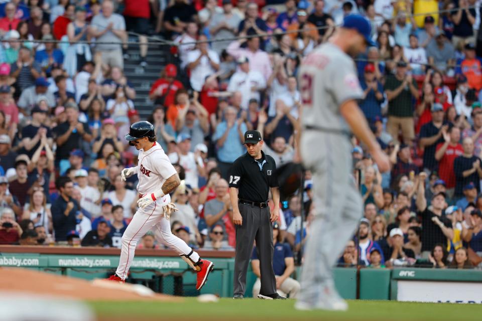 Boston Red Sox's Jarren Duran, left, rounds third base after hitting a solo home run off New York Mets' Max Scherzer, right, during the first inning of a baseball game, Saturday, July 22, 2023, in Boston.