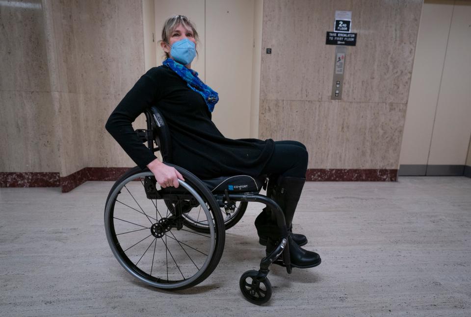 Jill Babcock, 51, of Detroit, moves around in her wheelchair at the Coleman A. Young Municipal Center, where she works as a supervisory program analyst for the policy team for the city of Detroit on Jan. 5, 2023. Babcock is a plaintiff in a disability rights case against the city, county, and state and is advocating for more disability-friendly and compliant measures. Using the bathroom in the building has been particularly problematic. Several people, including the public who widely use the building, don't have access to the restrooms because they are locked on the county side, so they are forced to hike to the basement of the city side of the building.