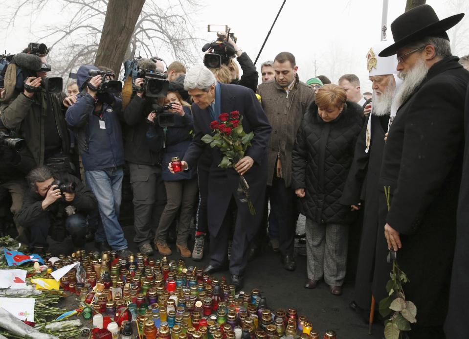 Secretary of State John Kerry places a candle and roses atop the Shrine of the Fallen in Kiev, Ukraine, Tuesday, March 4, 2014. The Shrine of the Fallen, located on Institutska Street, honors the fallen Heroes of the "Heavenly Sotnya" (Hundred). Over the course of the EuroMaidan protests, almost 100 protesters were killed by police. (AP Photo/Kevin Lamarque, Pool)