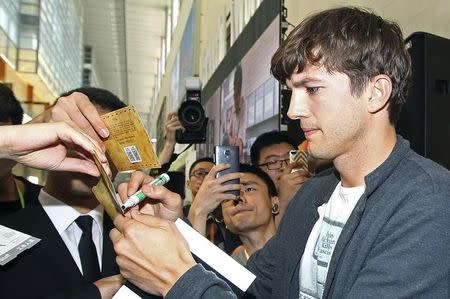 U.S. actor Ashton Kutcher signs autographs for his fans during a promotional tour for the movie "Jobs" in Beijing August 25, 2013. REUTERS/Stringer
