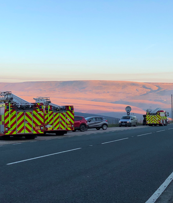 <em>Fire engines on Manchester Road as they tackle the fire on Saddleworth Moor (PA)</em>