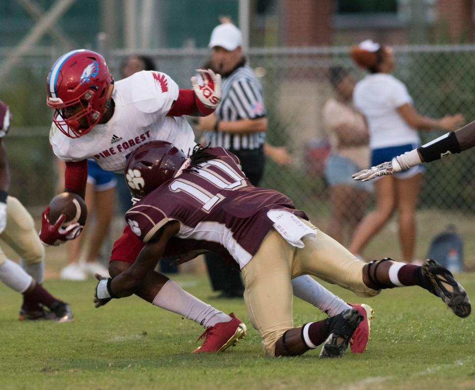 Pine Forest High School's Martin Emerson,(No. 1) breaks the tackle of Pensacola High Shcool's Deaaron Finklea,(No. 10) during the season opener Friday night. 