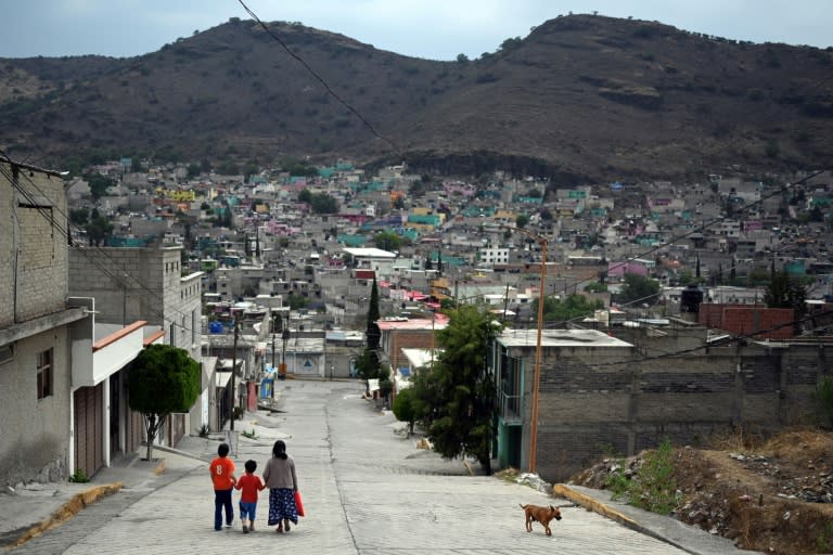 Eine Familie geht eine Straße in einem Viertel des bevölkerungsreichsten Bundesstaates Mexikos entlang, der sich auf die Wahl eines neuen Gouverneurs vorbereitet