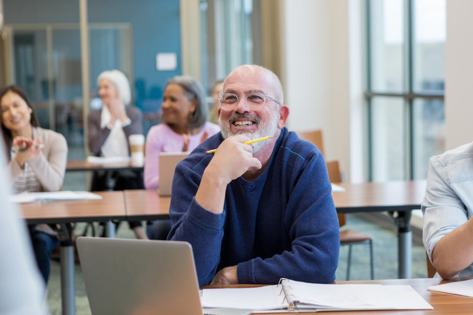 Sunk Cost Fallacy: A diverse group of students have fun during their adult education class at the local college.