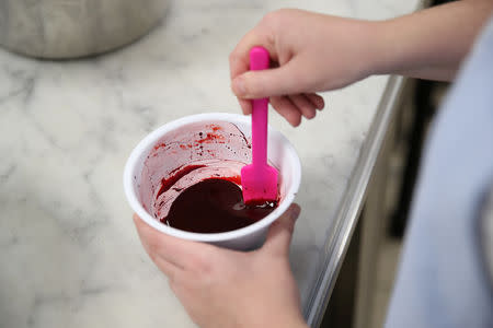 Baker Sophie Cabot mixes food colouring in the kitchen as she prepares the red velvet and chocolate wedding cake for the marriage at Windsor Castle of Britain's Princess Eugenie and Jack Brooksbank, at Buckingham Palace in London, Britain, October 10, 2018. Chris Jackson/Pool via REUTERS