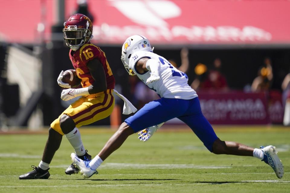 USC cornerback Prophet Brown is tackled by San Jose State cornerback Nehemiah Shelton.