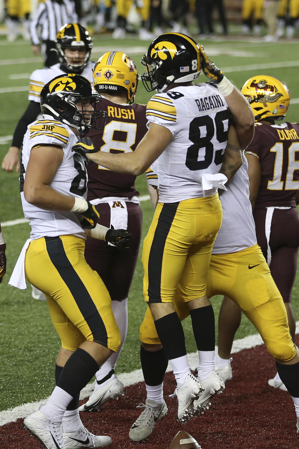 Iowa wide receiver Nico Ragaini (89) celebrates with tight end Sam LaPorta, left, and fullback Monte Pottebaum, obscured right, after Ragaini scored a touchdown against Minnesota during the first half an NCAA college football game Friday, Nov. 13, 2020, in Minneapolis. (AP Photo/Stacy Bengs)