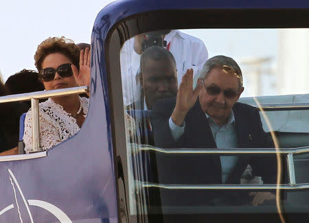 Brazil's President Dilma Rousseff (L) and her Cuban counterpart Raul Castro wave while riding on a tour bus during the inauguration of a port in Mariel on the outskirts of Havana in this January 27, 2014 file photo. REUTERS/Claudia Daut/File Photo