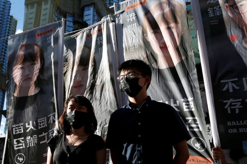 Pro-democracy activist Joshua Wong announces his plans to run for legislature next to pro-democracy district councillor Jannelle Leung, in Hong Kong