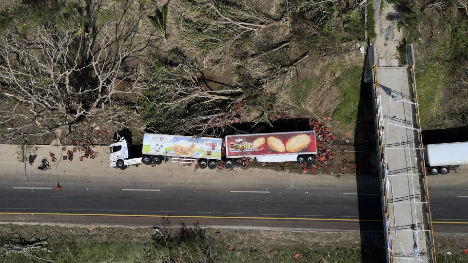An overturned semi lays on the shoulder of a highway in the aftermath of Hurricane Otis, on the outskirts of Acapulco, Mexico on Friday, October 27, 2023. - Felix Marquez/AP