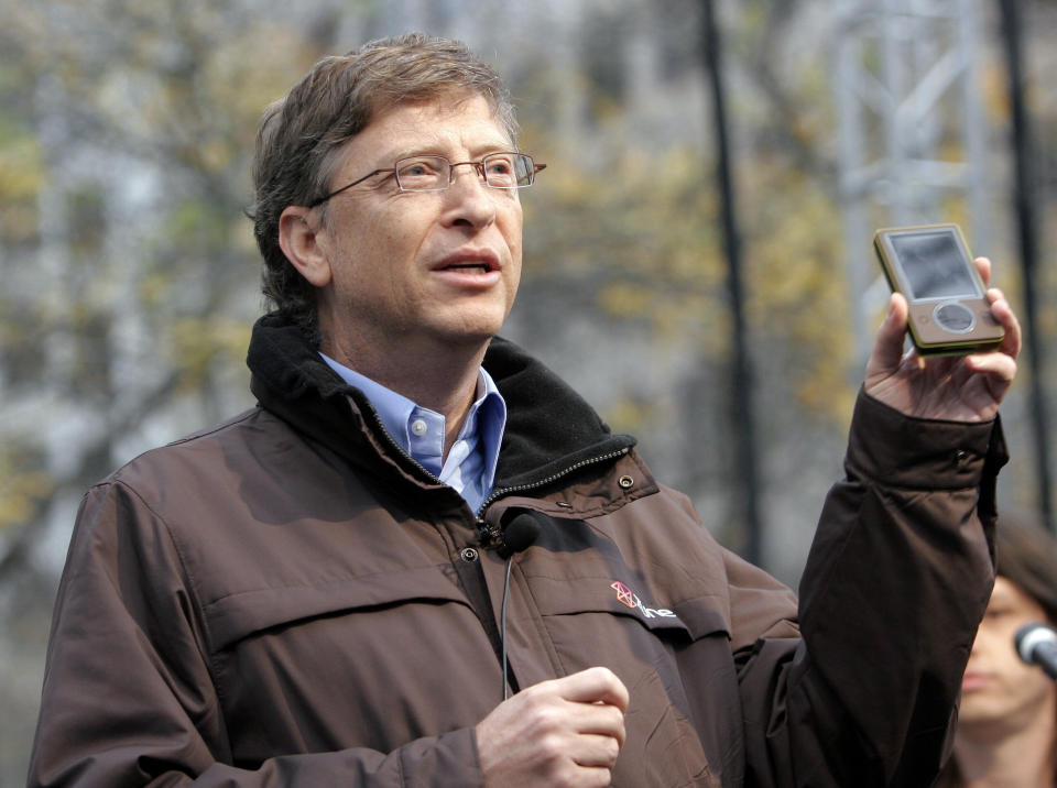 Microsoft chairman Bill Gates shows off the Zune media player to a crowd at a launch party in downtown Seattle November 13, 2006. The 30-gigabyte player, which goes on sale to the public November 14th, features wireless technology, a built-in FM radio and three-inch screen that can play both music and videos. REUTERS/Robert Sorbo (UNITED STATES)