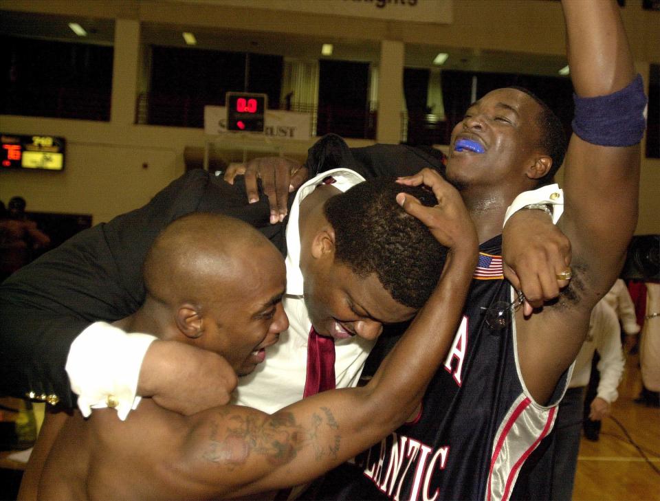 Florida Atlantic coach Sidney Green, center, celebrates with players Anthony Slater, left, and Jeff Cowans after they defeated Georgia State 76-75 in the Atlantic Sun tournament championship game in Orlando, Fla., Saturday, March 2, 2002.