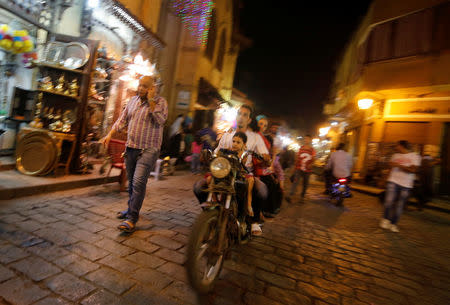 A man rides his motorcycle with his family around shops in old Islamic Cairo, Egypt August 18, 2016. Picture taken August 18, 2016. REUTERS/Amr Abdallah Dalsh