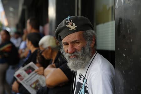 Humberto Garcia, 66, lines up outside a supermarket waiting for any basic goods to be sold in Caracas January 19, 2015. REUTERS/Jorge Silva